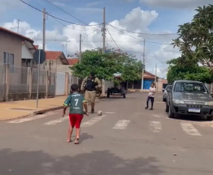 Policiais militares aceitam convite de crianças durante patrulhamento e jogam futebol na rua