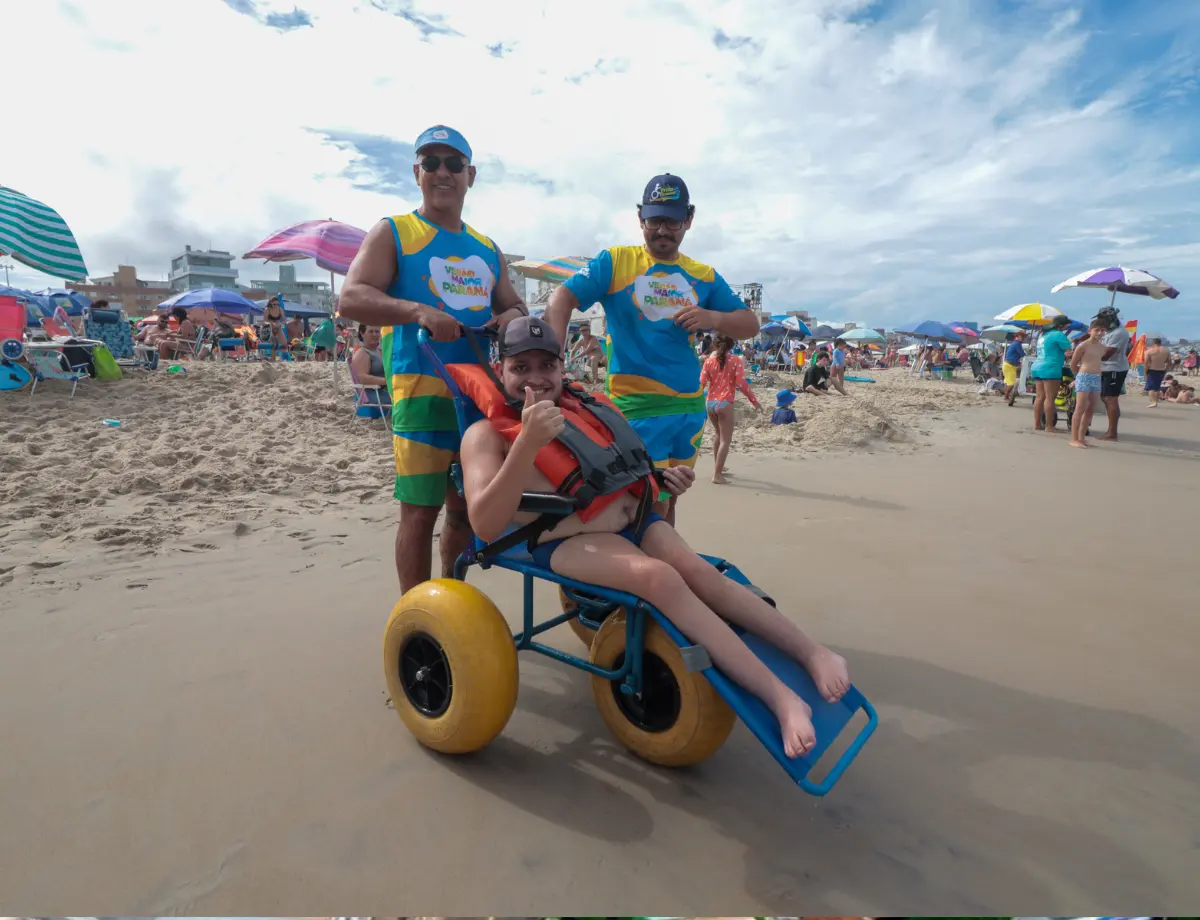 Família passa férias no Litoral do Paraná para filho tomar banho de mar com cadeira anfíbia